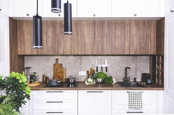 舒适的白色木质厨房内饰，现代经典风格，配有感应炉、黑色水槽和家具配件、酒瓶架、刀具磁铁、厨房用具和炊具。真实照片图片下载
