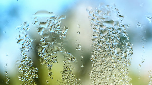 玻璃上的水滴。滴落的雨滴纹理背景。雾气弥漫的窗户特写，水滴顺着窗户流下。空气湿度增加。雨天。蓝绿色调。高质量照片。图片下载