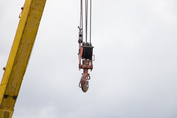 建筑工地上的起重机钩，背景是多云的天空，特写照片图片下载