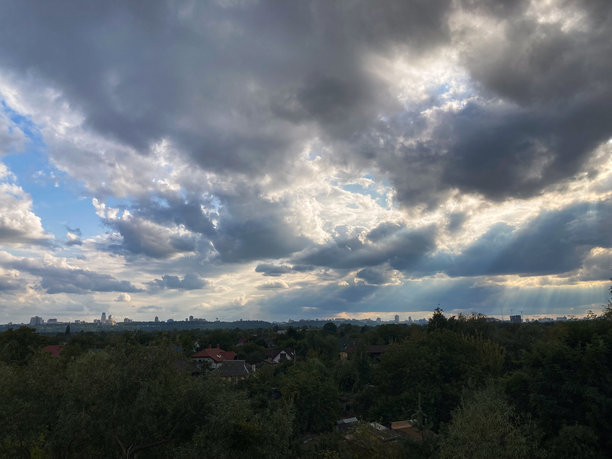 宁静的乡村风景，展现日出或日落时的云彩、郁郁葱葱的植被和房屋。这是一张自然主义的照片，没有任何文字、人工元素或数字化处理。图片下载
