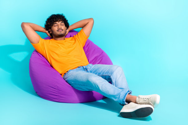 全身照片，展现一个温和、平静、安详的人，舒适地躺在睡袋中，双手放在头后，背景为青绿色。图片下载