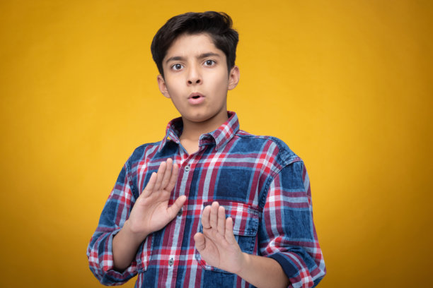 穿着格子衬衫的年轻男孩，背景为黄色，孤立拍摄的照片图片下载