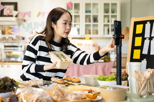 小企业主正在销售。亚洲糕点店老板喜欢在社交媒体上发布她的蛋糕照片和评论，或通过在线营销直播来宣传小企业，利用社交媒体的力量和在线营销来赚取更多收入。图片下载