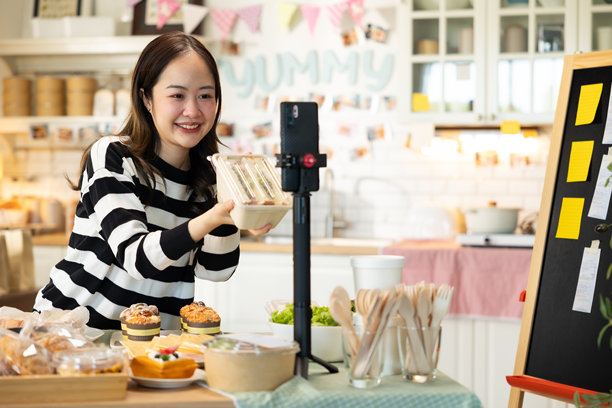 小企业主正在销售。亚洲面包店的蛋糕店老板喜欢在社交媒体上发布她的蛋糕照片和评论，或通过在线营销直播来宣传，利用社交媒体的力量和在线营销为小企业赚取更多收入。图片下载