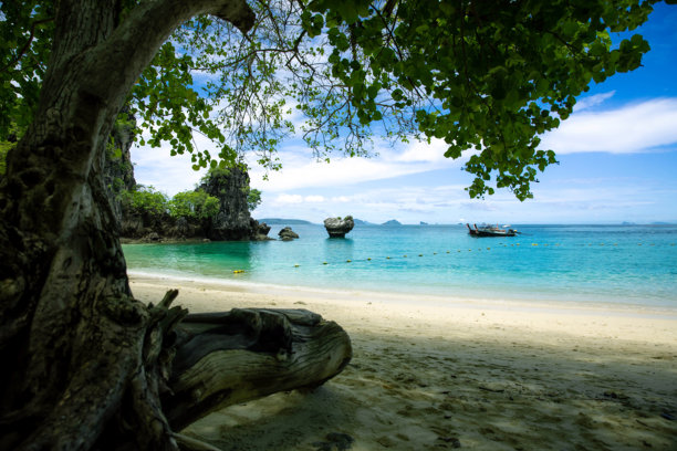 泰国甲米令人惊叹的热带海滩，拥有柔软的白沙、翡翠蓝的海水、壮观的石灰岩悬崖和传统的长尾船。非常适合海滩照片、屏幕保护程序和热带岛屿背景。图片下载