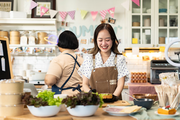 小企业主正在销售。亚洲面包店的蛋糕店老板喜欢在社交媒体上发布她的蛋糕照片和评论，或通过在线营销直播来宣传，利用社交媒体的力量和在线营销为小企业赚取更多收入。图片下载