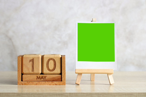 木制万年历显示5月10日，带有绿色背景的照片框图片下载