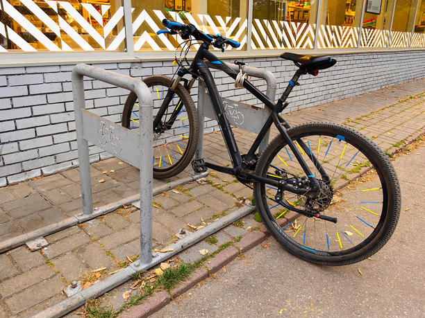 一辆黑蓝色的成人运动或山地自行车停放在超市或带玻璃展示柜的商店的自行车停车区。秋天。俄罗斯。下诺夫哥罗德。赫罗·里亚布采夫街。2024年10月。照片。图片下载