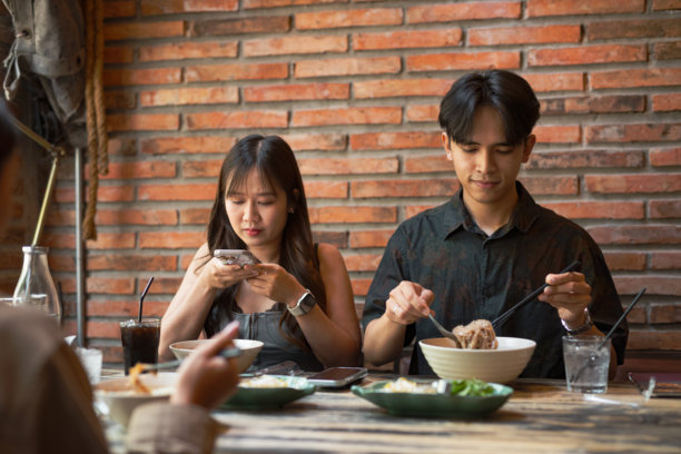 朋友们在餐厅一起用餐并拍摄食物照片图片下载