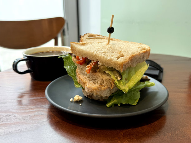 桌子上的三明治，配有烤椒、茄子、生菜、橄榄油和奶酪。早餐外出概念。手工手机照片，选择性对焦，非人工智能。图片下载