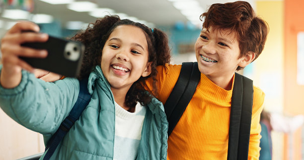 学校走廊，孩子们微笑自拍，学习和课堂。学生们在校园走廊，拍摄个人资料照片，记录教育、社交媒体和早晨的回忆。图片下载