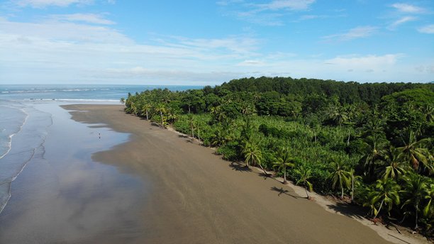 哥斯达黎加乌维塔海滩的无人机航拍照片。浅水中云彩的理想倒影与深绿色热带丛林相映成趣。冒险与独自背包旅行中美好的中美洲体验。图片下载