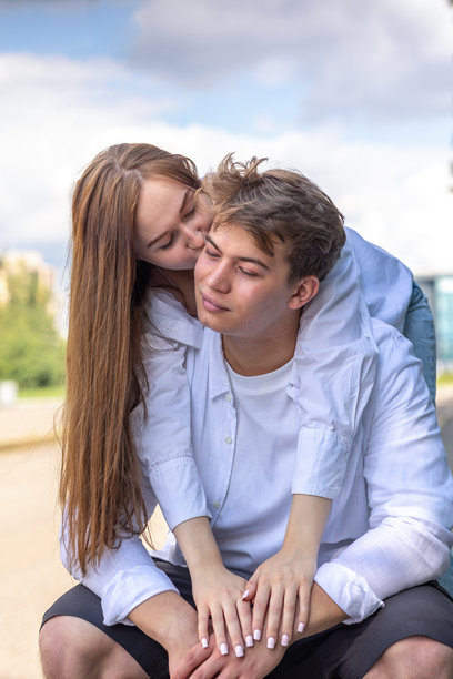一对恋人的特写肖像。年轻的男女在温暖的夏日里在公园散步并享受乐趣。竖版照片图片下载