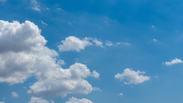 高分辨率照片，展示正午时分深蓝色的天空和蓬松的白云。图片下载