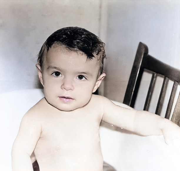 复古的婴儿女孩在盆中洗澡的肖像。孩子看起来非常专注。1994年的复古照片。图片下载