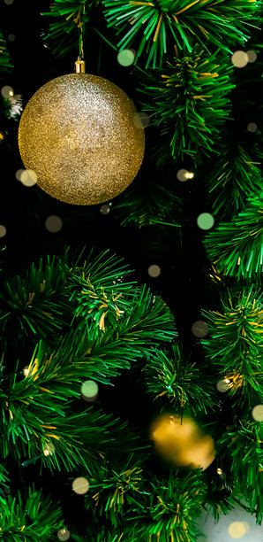 圣诞树上挂着的金色球的特写垂直照片。图片下载