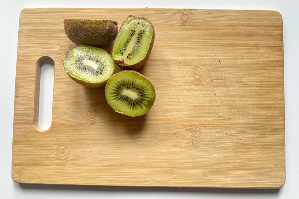 竹板上的猕猴桃。多汁的水果，鲜艳的绿色果肉。适合健康饮食、水果和素食主义的主题。图片下载