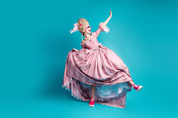年轻贵族女性穿着巴洛克风格的裙子在青色背景下优雅舞蹈的全身照片图片下载