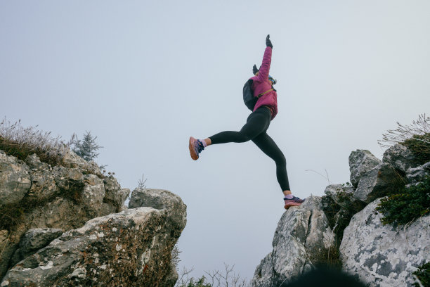 雾气弥漫的山地风景中的越野跑者图片下载