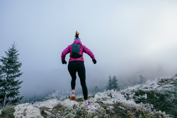 雾气弥漫的山地风景中的越野跑者图片下载