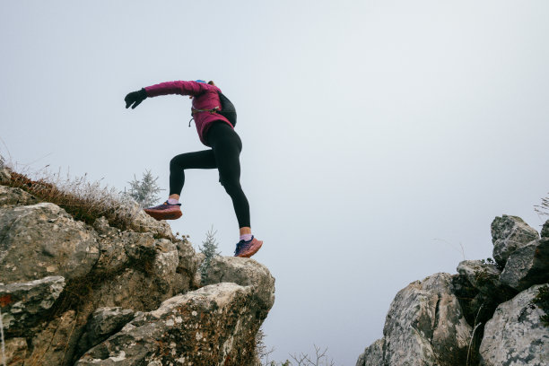 雾气弥漫的山地风景中的越野跑者图片下载
