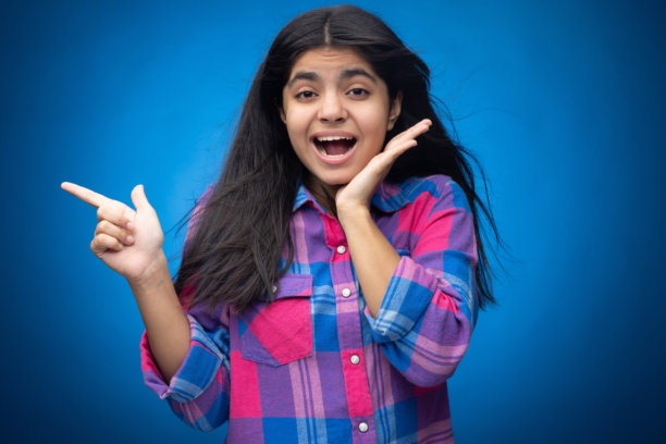 迷人可爱的年轻女孩，直发，背景为蓝色，肖像照片图片下载