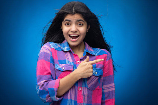 迷人可爱的年轻女孩，直发，背景为蓝色，肖像照片图片下载