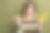 可爱的年轻女士的照片肖像，穿着时尚的印花针织衣服，指向空白空间，背景为卡其色。图片下载