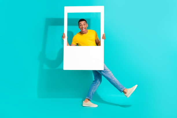 全身照片，轻松愉快的人在蓝绿色背景上走动跳舞，手中拿着纸质相册和卡片。图片下载