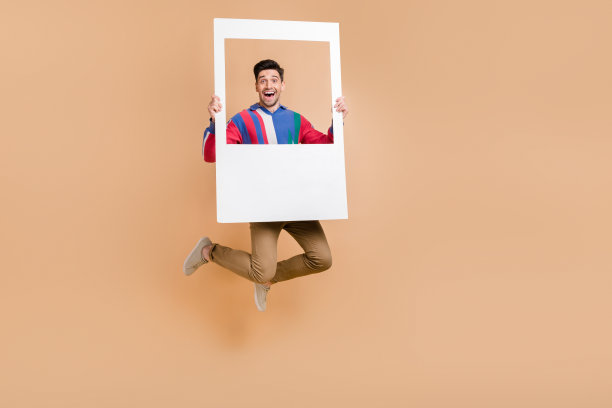 全身照的时尚活力商人手持纸张，拍摄照片区的纪念活动，背景为米色。图片下载