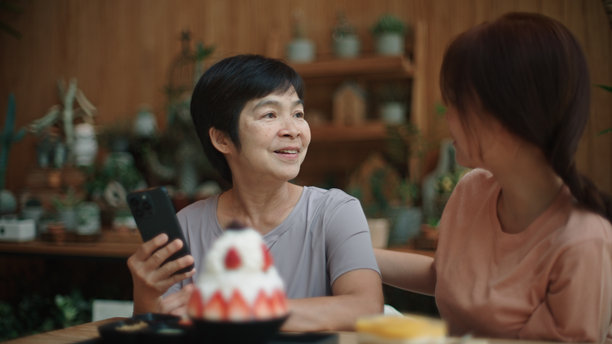 母女在咖啡馆拍摄甜点照片以分享在社交媒体上。图片下载