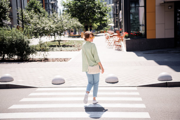 阳光明媚的秋日，穿着时尚衣服的可爱女孩在咖啡馆度过周末时光的全身照片图片下载