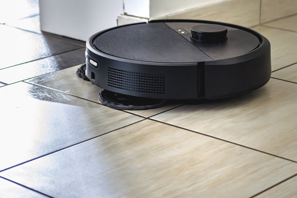 带尘埃的机器人吸尘器，真实生活照片，节省时间并能进入难以到达的地方图片下载