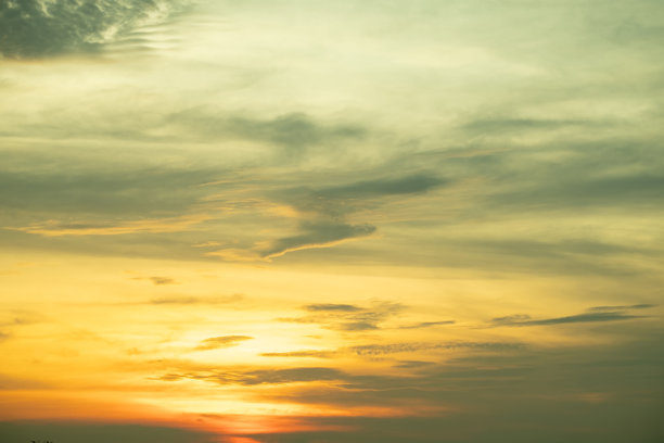 美丽的日落景观，奢华柔和的渐变橙金色云彩和阳光映照在蓝色戏剧性的天空上，完美适合作为背景，早晨、傍晚、黄昏，气候变化，横向日落照片图片下载