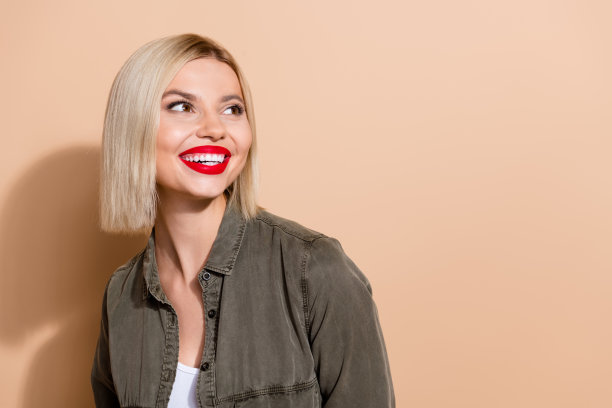 特写照片，漂亮的金发短发女士凝视空旷的空间，旁边是有趣的广告海报，背景为米色。图片下载