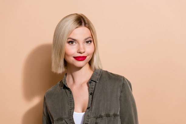 特写照片，吸引人的女性专业日常妆容，红色丰盈的嘴唇，穿着卡其色衬衫，背景为米色。图片下载