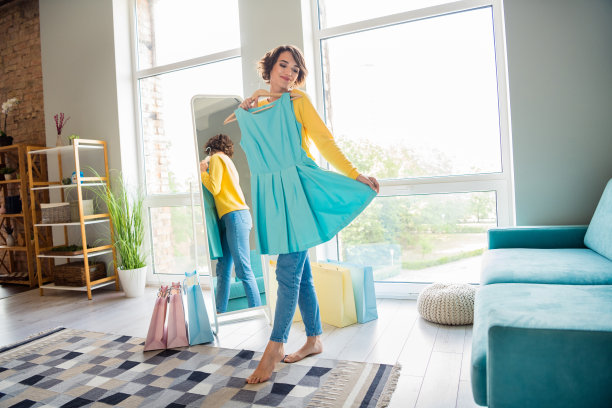 可爱的女孩在室内的镜子前试穿新裙子的全身照片图片下载