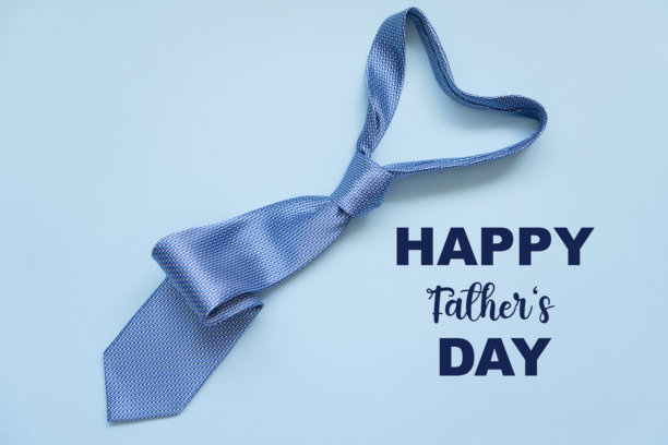 父亲节概念。蓝色背景上蓝色领带的俯视照片，留有空白空间。图片下载