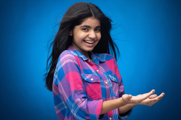 迷人可爱的年轻女孩，直发，背景为蓝色，肖像照片图片下载