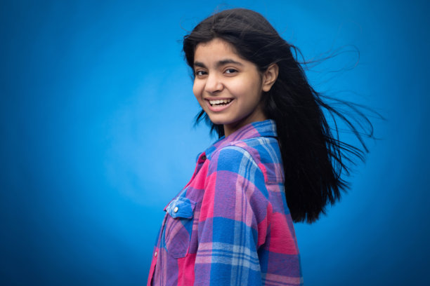 迷人可爱的年轻女孩，直发，背景为蓝色，肖像照片图片下载