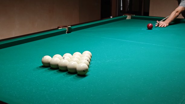 游戏开始，第一杆。绿色台球桌上的俄罗斯台球。玩家用球杆击打红球，特写打破了三角形。休闲运动爱好。高质量照片图片下载