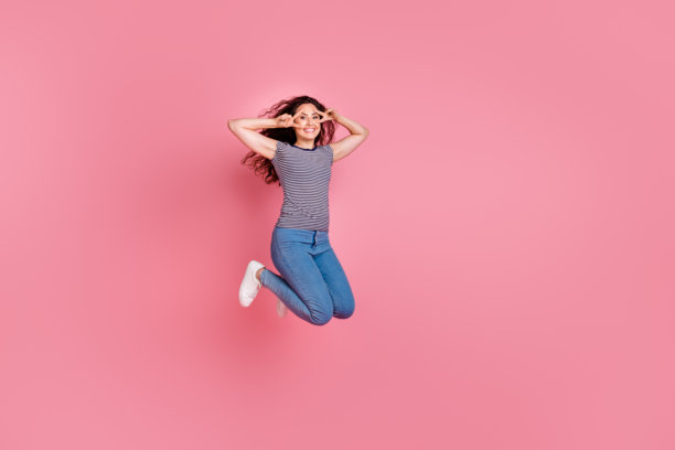 活泼的年轻西班牙裔运动女孩用友好的问候手势遮住脸部的全身照片，背景为粉色。图片下载