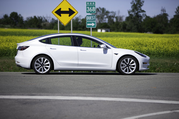 白色特斯拉汽车在路上。图片下载