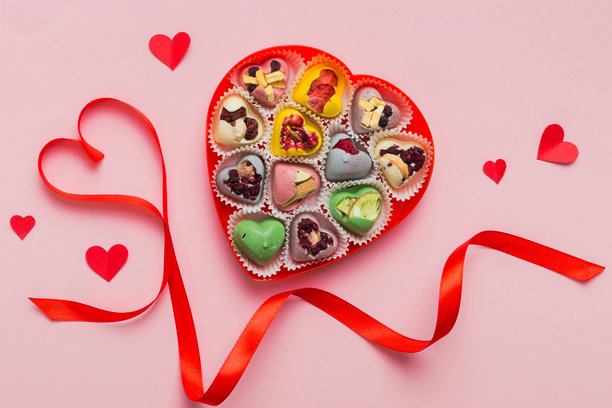 情人节构图：甜蜜的糖果，带有蝴蝶结的礼品盒和红色毛毡心形，照片模板，背景。俯视图，留白空间。图片下载