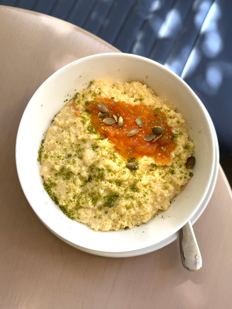 白碗中的小米粥配杏仁酱、南瓜籽和开心果碎。健康碳水化合物概念。手工手机照片，选择性对焦，非人工智能。图片下载