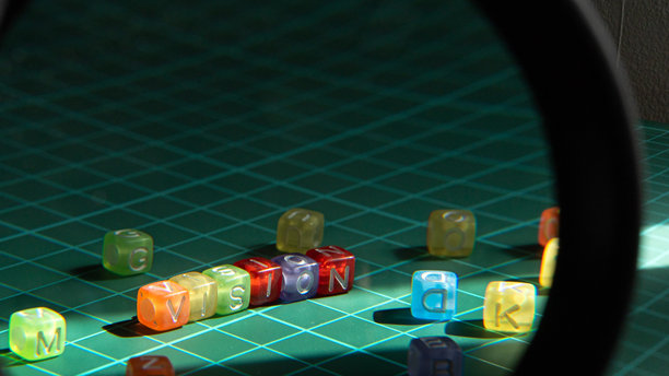 用彩色字母珠拼写的“愿景”在绿色格子垫上图片下载