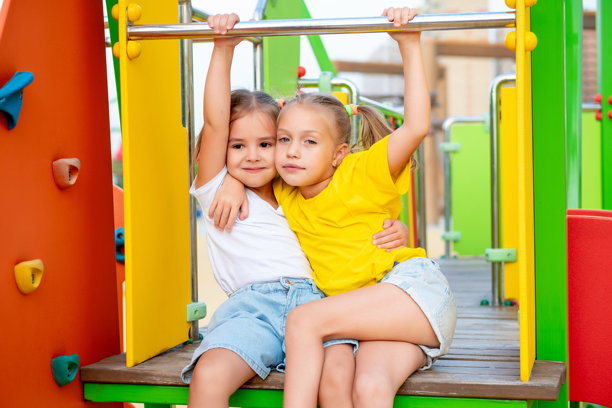孩子们在游乐场玩耍，享受夏天的乐趣，这是一张明亮的夏季儿童假期照片，两个小女孩在公园里欢笑玩耍。图片下载