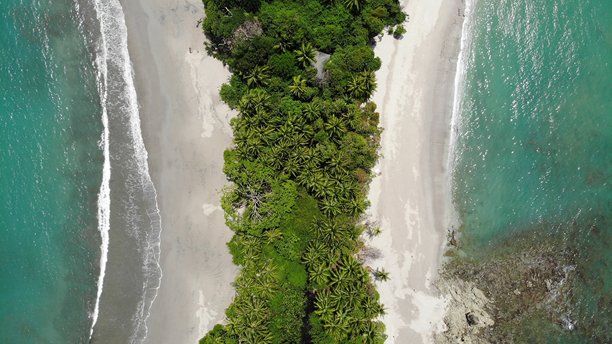 令人印象深刻的从上往下拍摄的无人机航拍照片，展示了哥斯达黎加国家公园内偏远的曼努埃尔·安东尼奥海滩。空旷对称的沙洲，深绿色的棕榈树指向小热带岛屿。中美洲的自然风光。自然的完美。图片下载