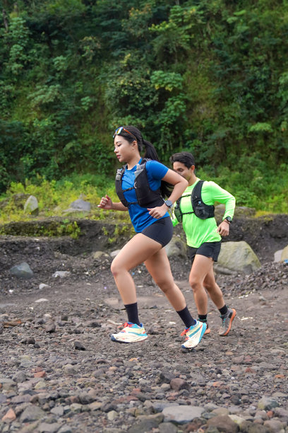 亚洲越野跑者在森林山地的岩石小径上慢跑图片下载