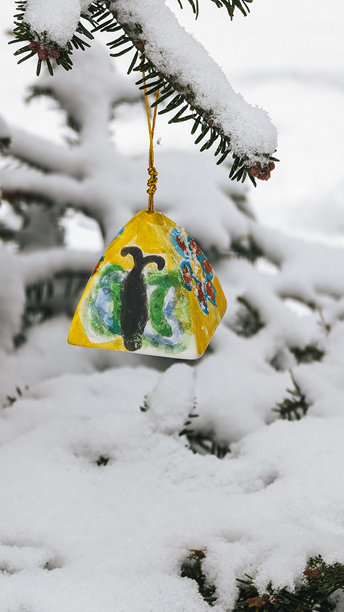 色彩斑斓的手绘三角装饰品悬挂在雪-covered树枝上。冬季雪景与被雪覆盖的常青树。图片下载